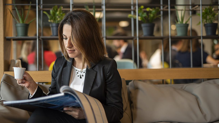 A woman is reading while having coffee