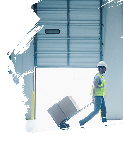 Indian worker pulling hand truck near open loading dock doors