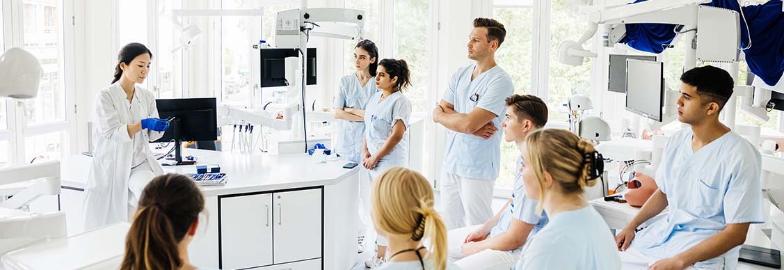 A group of students listening to their teacher together in a modern university laboratory