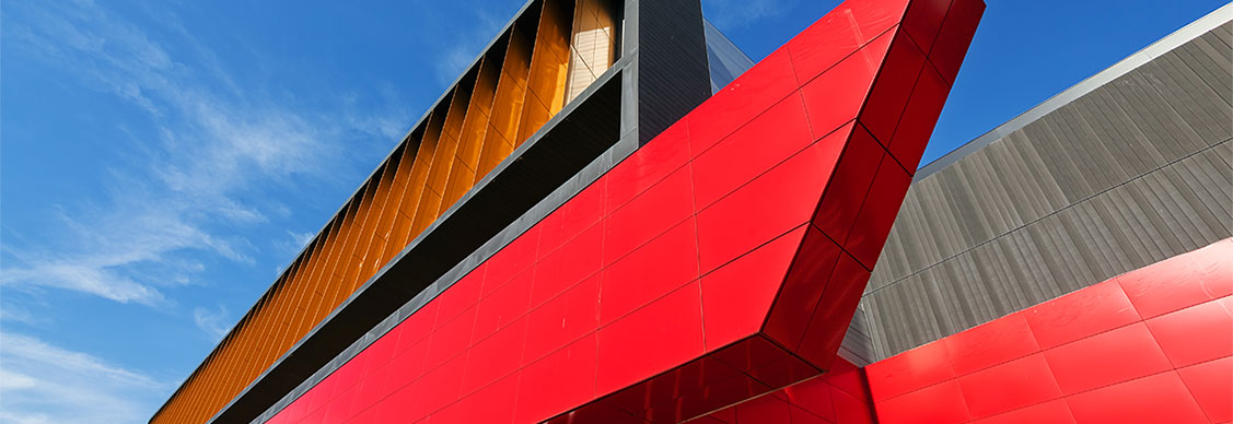 details of aluminum facade with colorful red and orange panels on large shopping mall