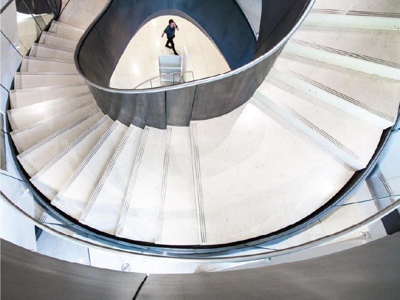 Man walking up the spiral staircase