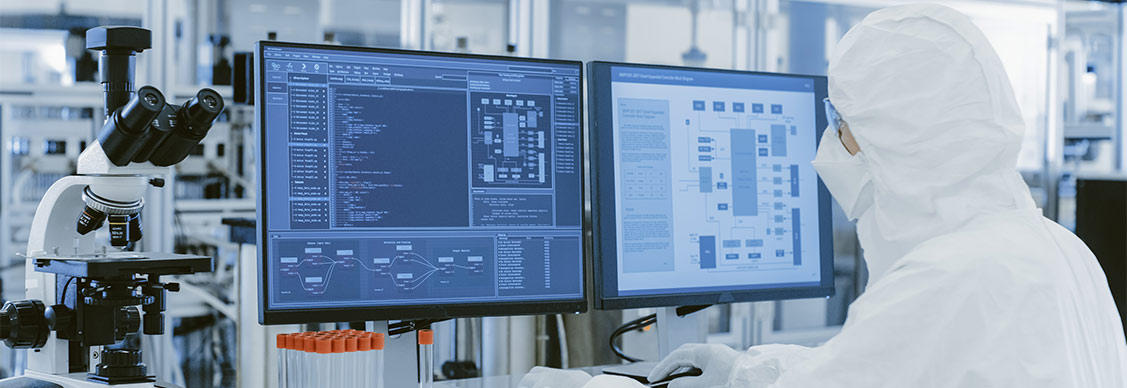 Healthcare professional in hazmat suit using computer
