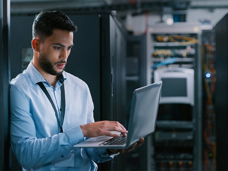 Man using laptop in data center