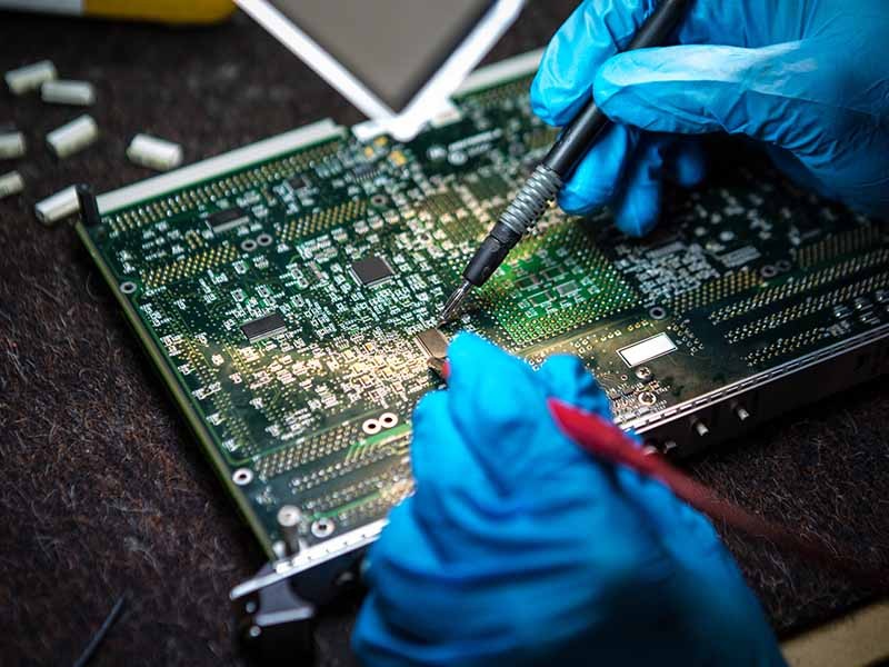 Men working on circuit board