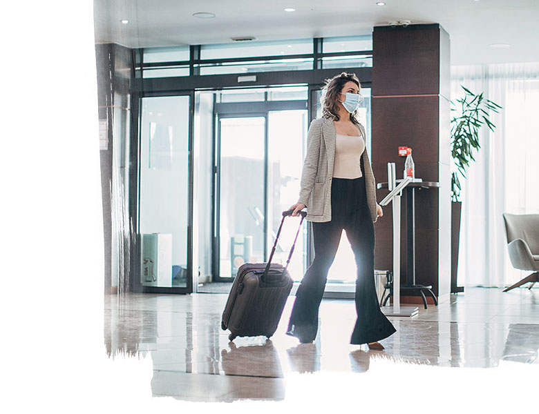Beautiful woman with medical mask arriving in hotel