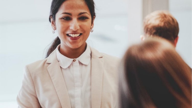 Brunet corporate woman smiling at her colleague