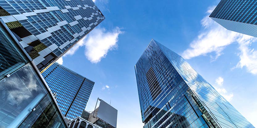 Down angle photo of glass buildings with clouds