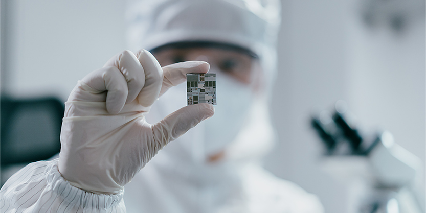 Female engineer inspecting wafer chip in laboratory