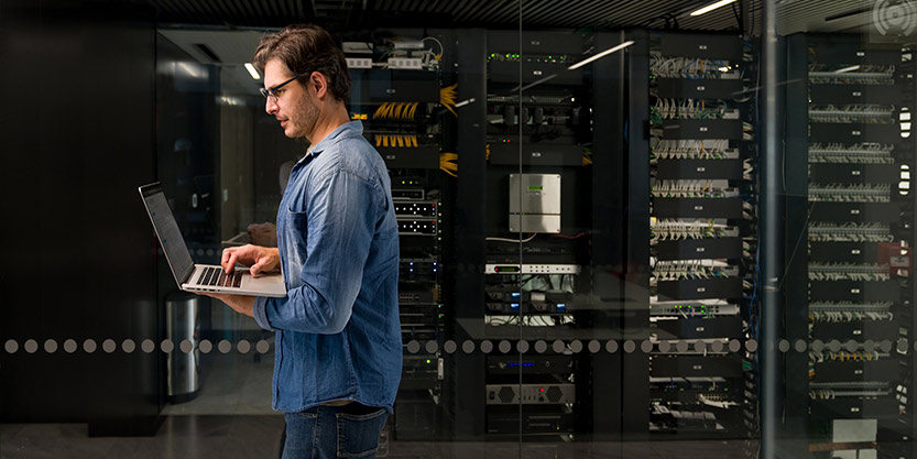 Man walking inside a room with laptop