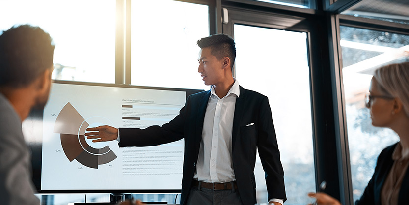 young businessman giving a presentation to his colleagues in an office