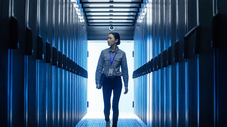 A lady with a lanyard walking through a data centre facility