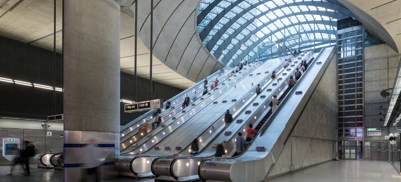 Commuters using escalators getting to subway in canary wharf london