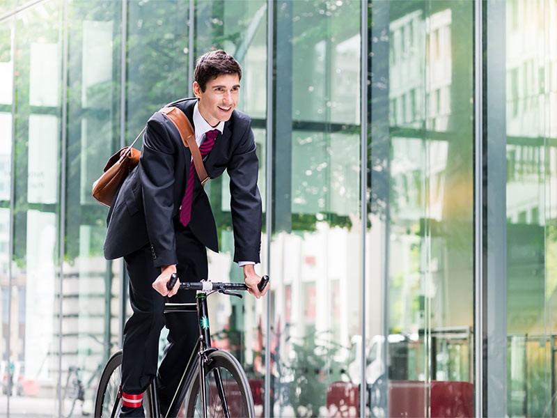 Cheerful young employee riding an utility bicycle in Berlin