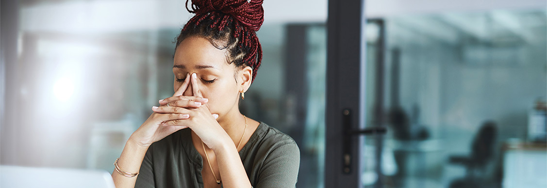 woman looking stressed out while working in an office