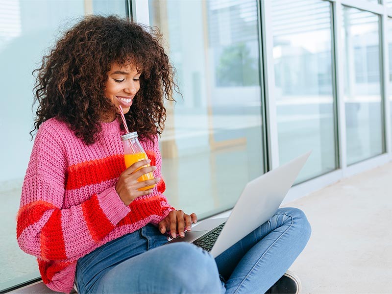 Woman working on laptop on balcony