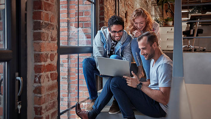 Professionals working on laptop discussing Ai